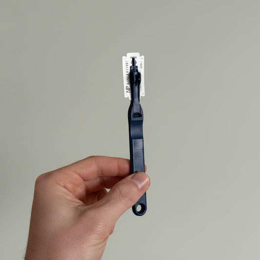 Hand holding a blue bread lame