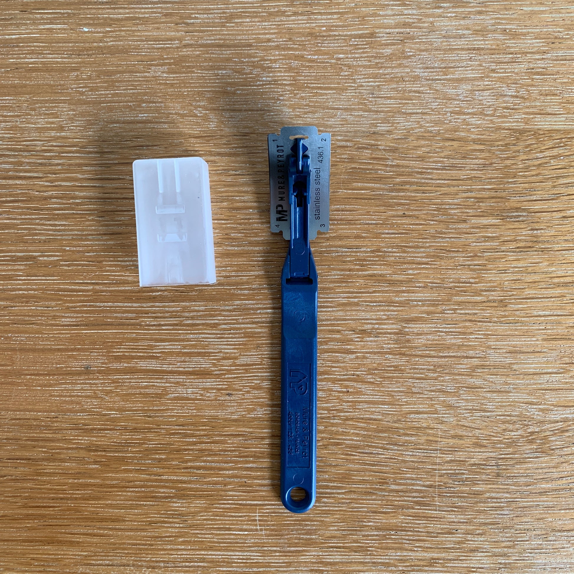 Blue plastic tool and white card on a wooden surface